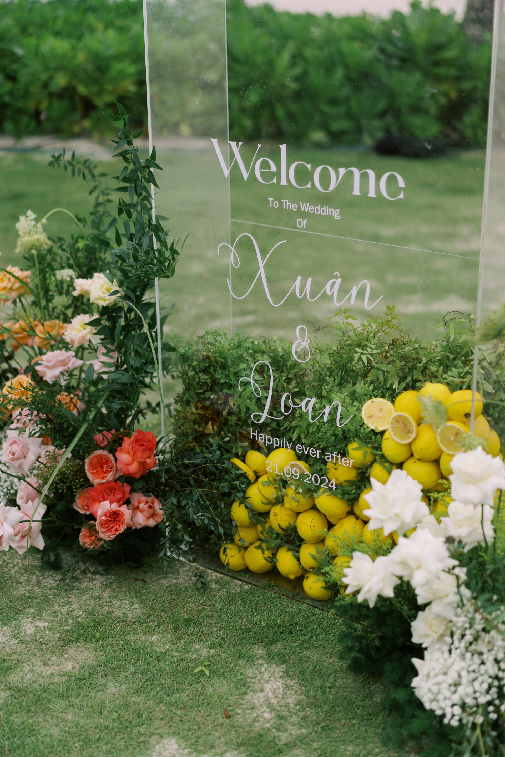 Wedding welcome sign decorated with flowers and lemons.